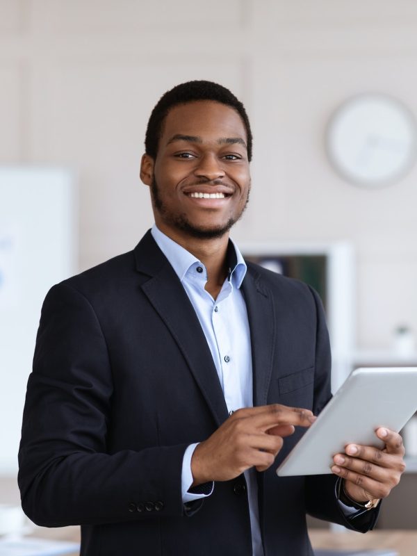 smiling-black-entrepreneur-holding-digital-tablet-office-interior.jpg